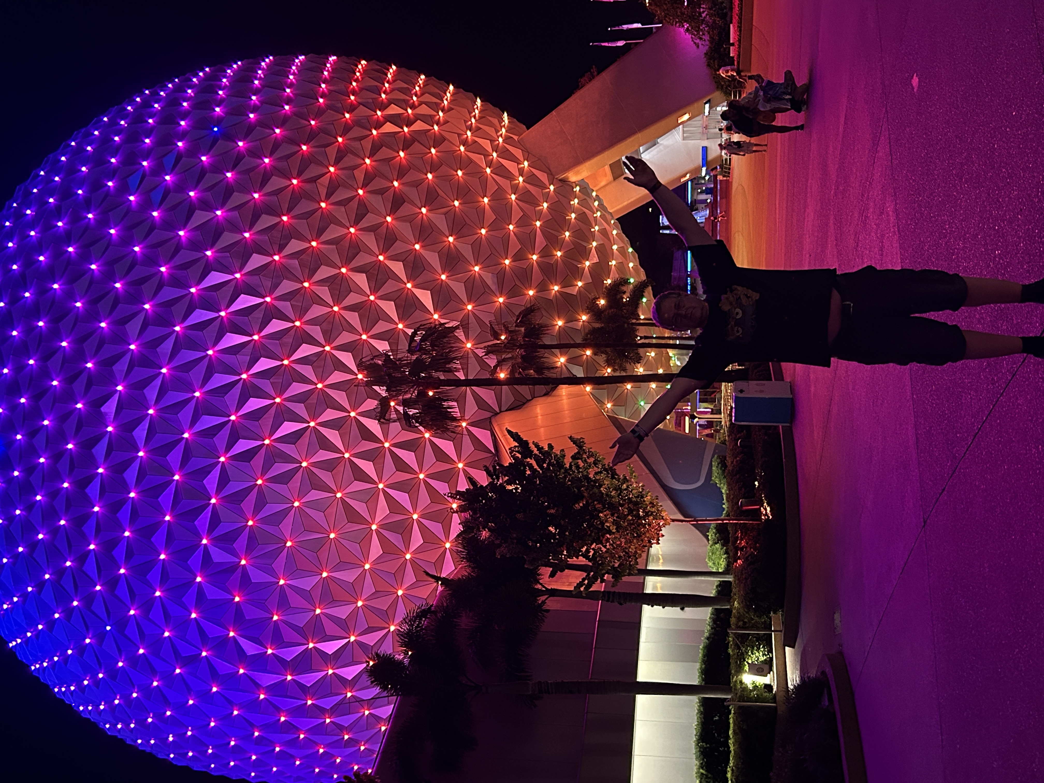 Pictures shows a multi coloured large ball with a man standing underneath it