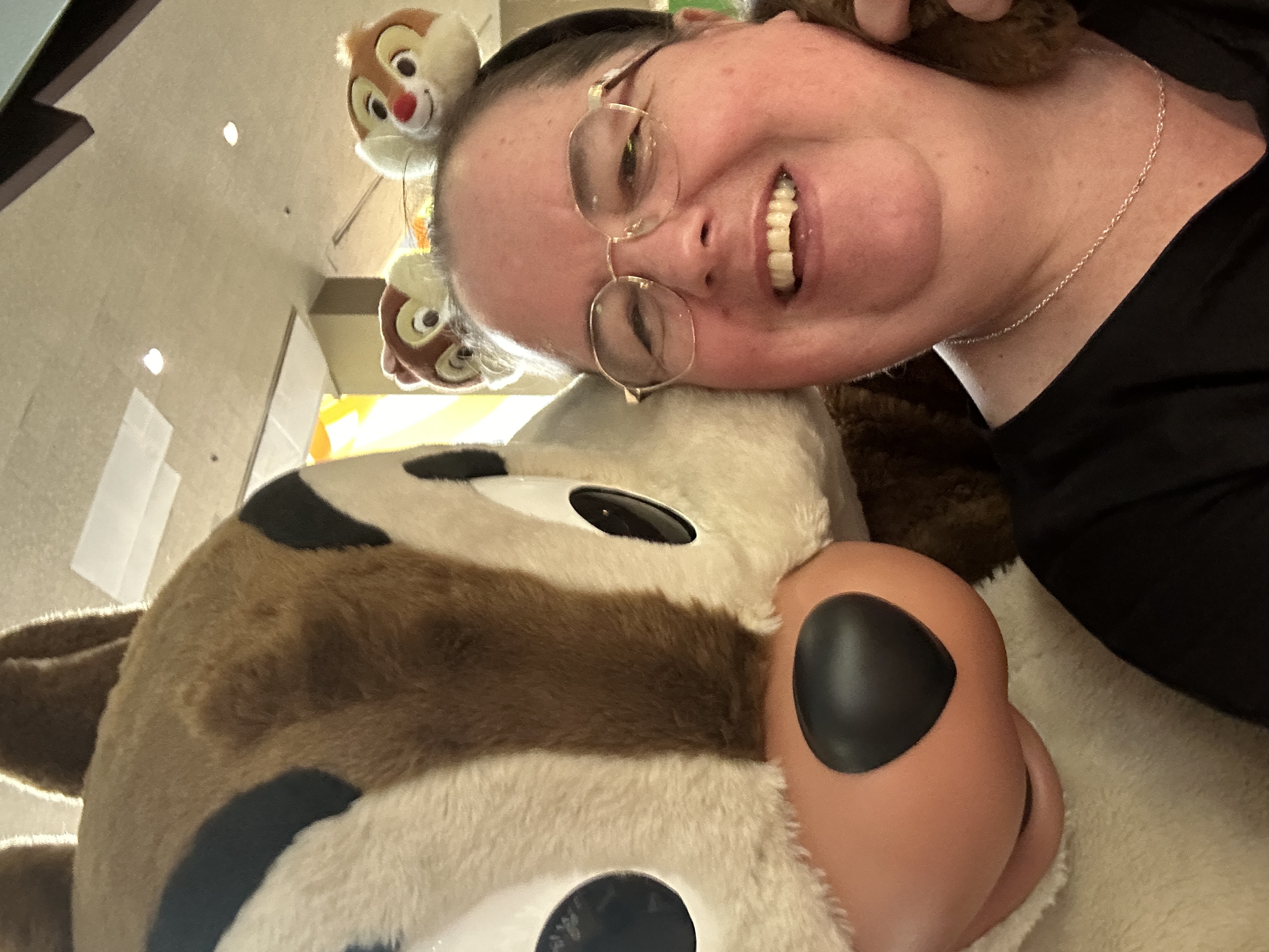 Image shows a furry chipmunk next to a lady in mickey mouse ears