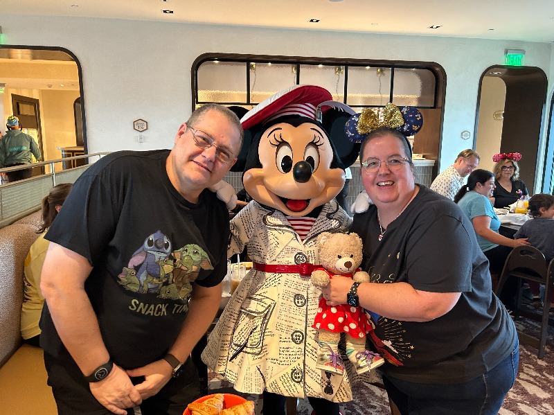 image shows a man and woman posing with Minnie Mouse