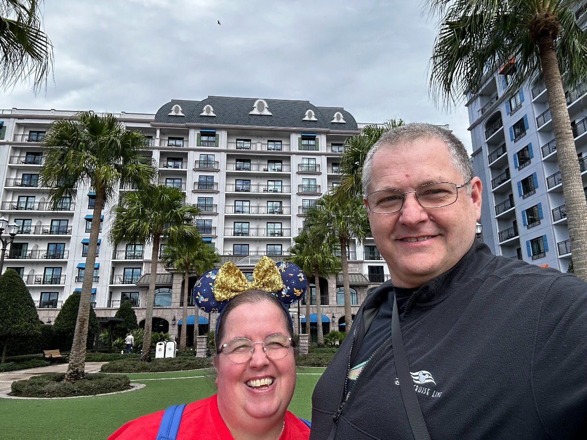 Image shows a man and woman standing in the grounds of a hotel