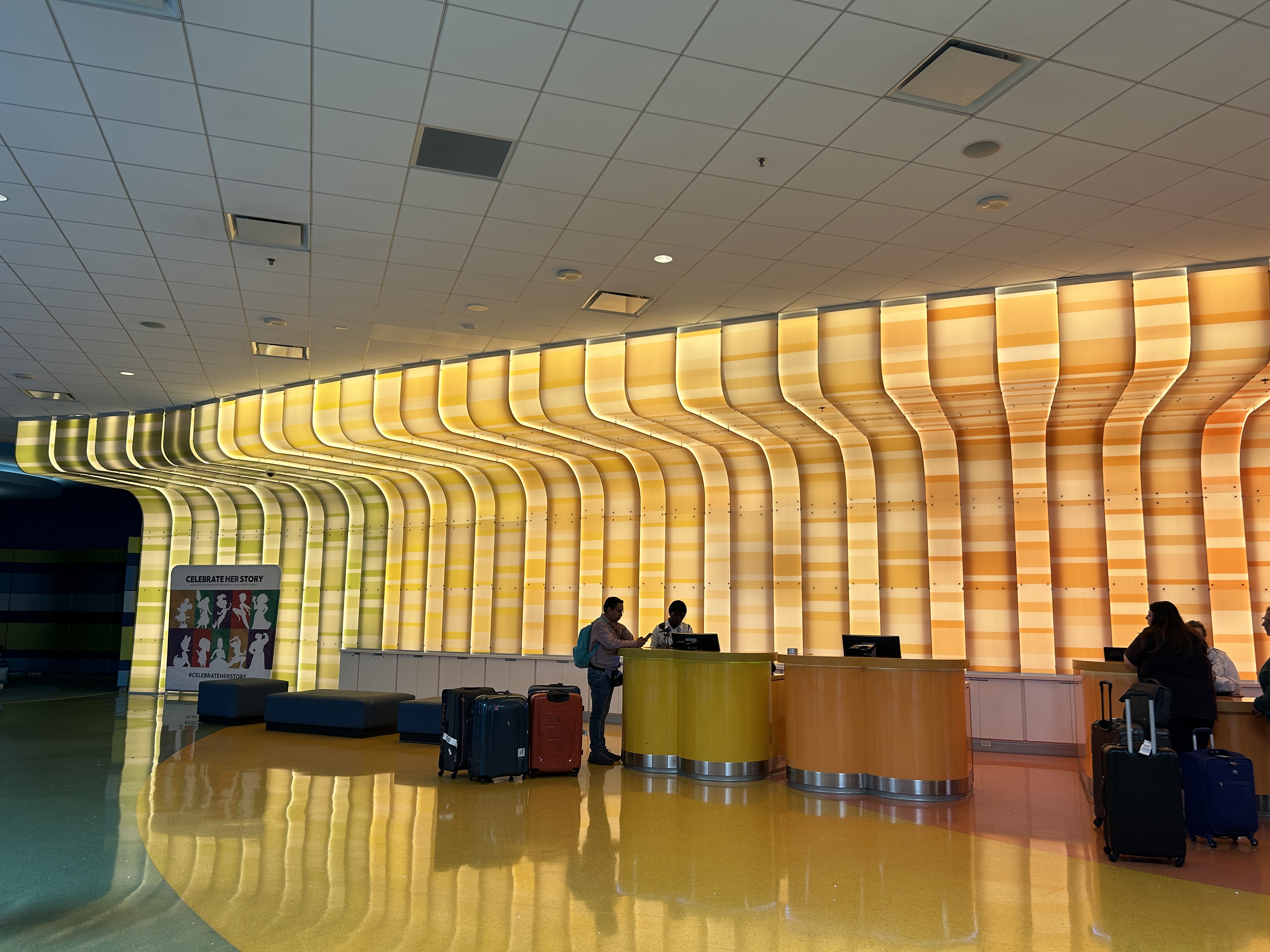 Image shows the reception area of the hotel with orange lighting on the ceiling