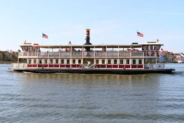 Image shows a two tier boat with flags on water