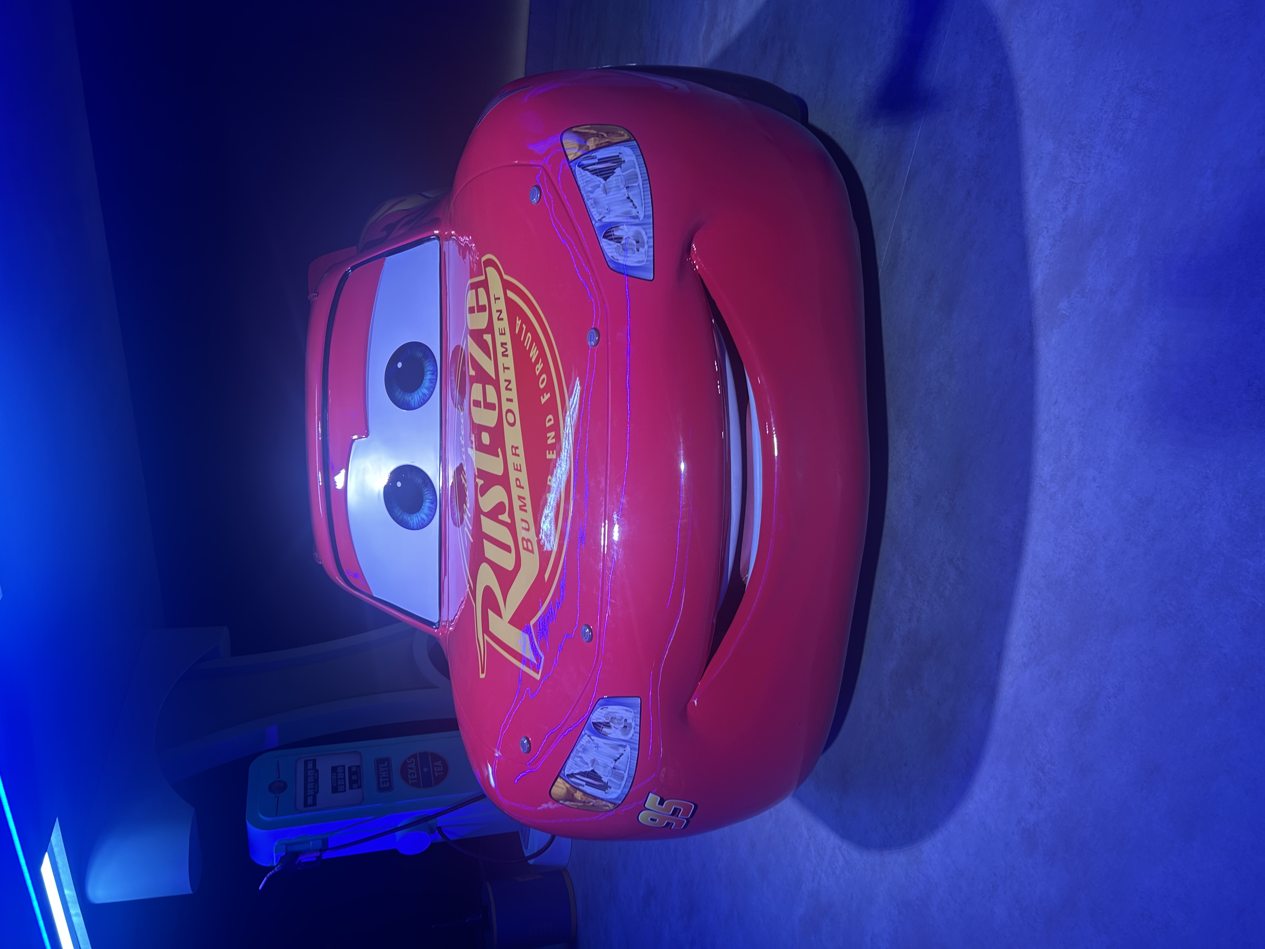A red car with eyes on the windscreen and yellow writing on the bonnet