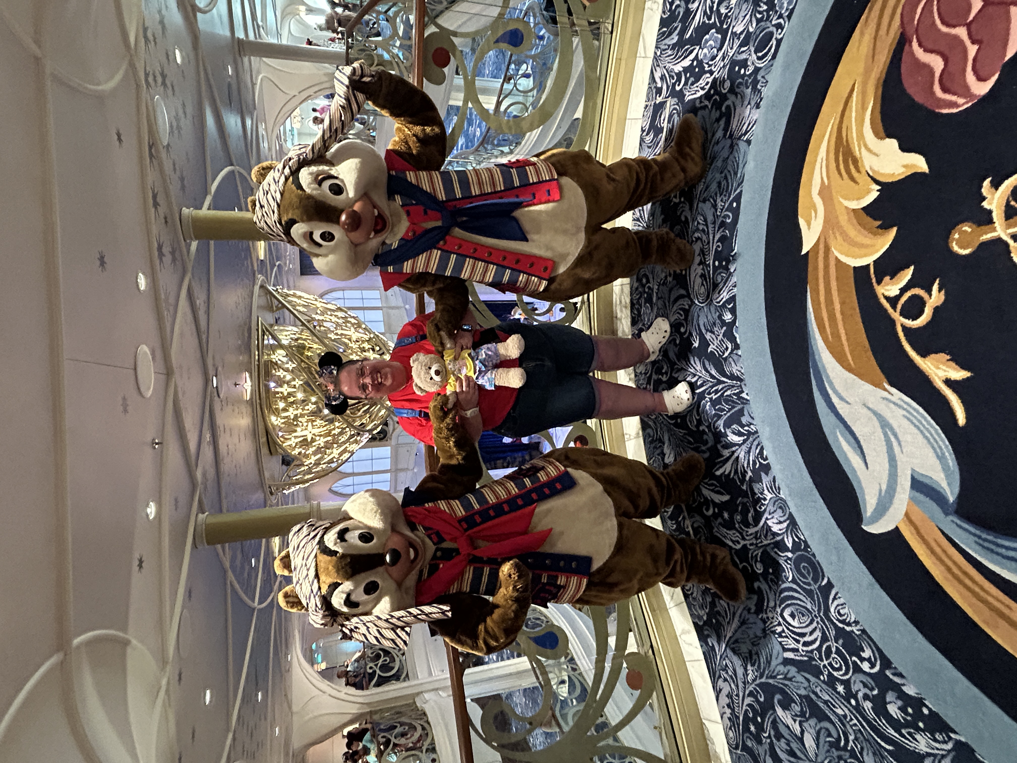 Image is on a balcony of two brown and whiite chipmunks with a lady in the middle
