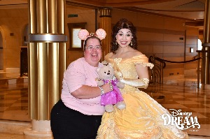 images shows a lady holding a bear with mickey ears next to a disney princess
