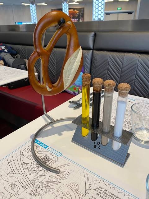 Oversized pretzel bread service with condiments served in test tubes at Pym Kitchen