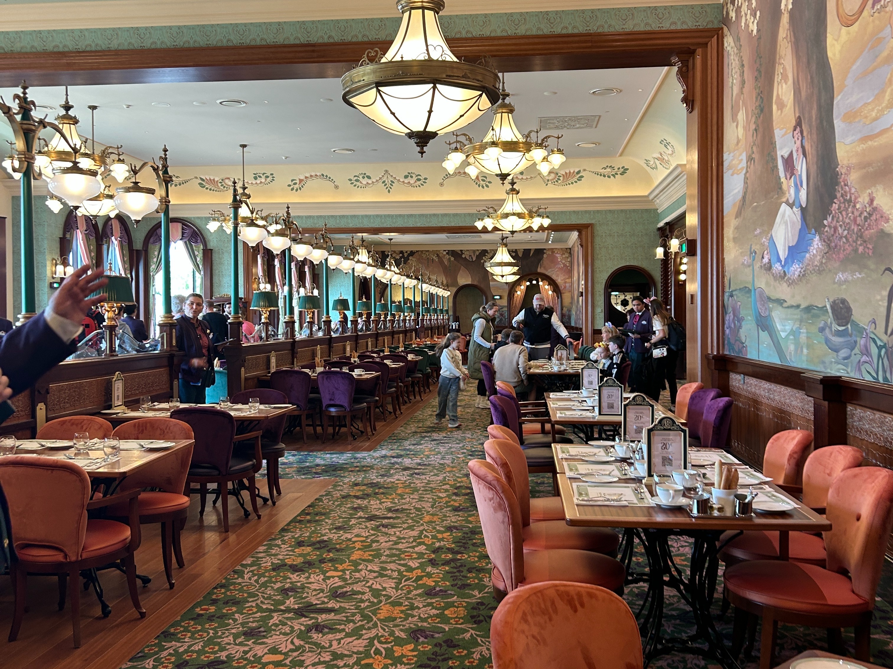 Looking in the restaurent there are rows of tables, and chandaliers as lighting, room is very bright and airey