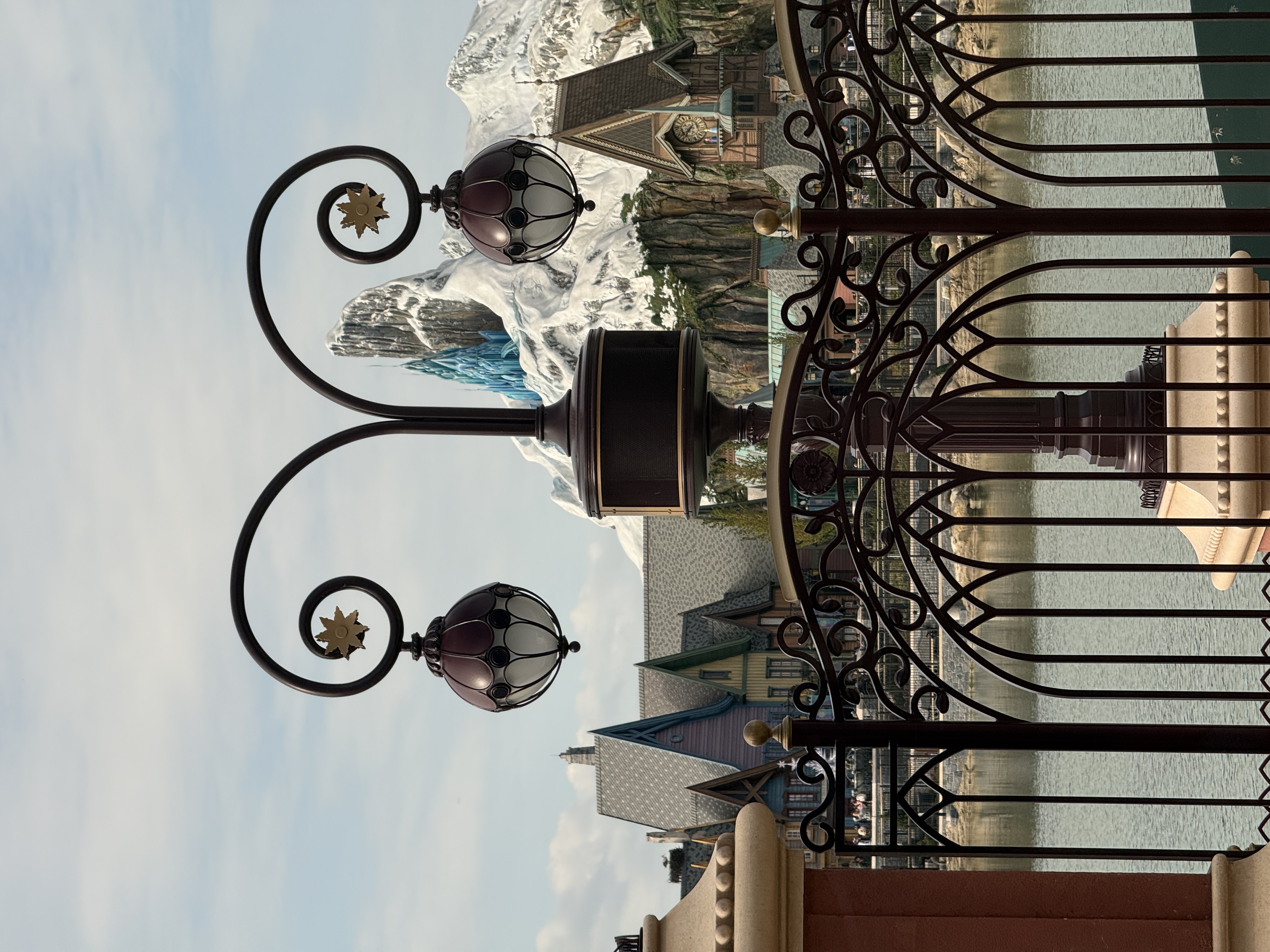 A look out of a window accorss a lake of water with a snow capped mountain and blue ice castle upon