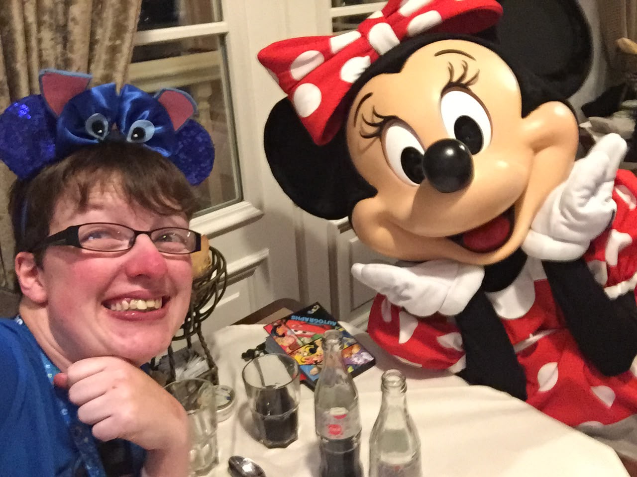 Image shows a lady with stich headband having dinner with minnie mouse