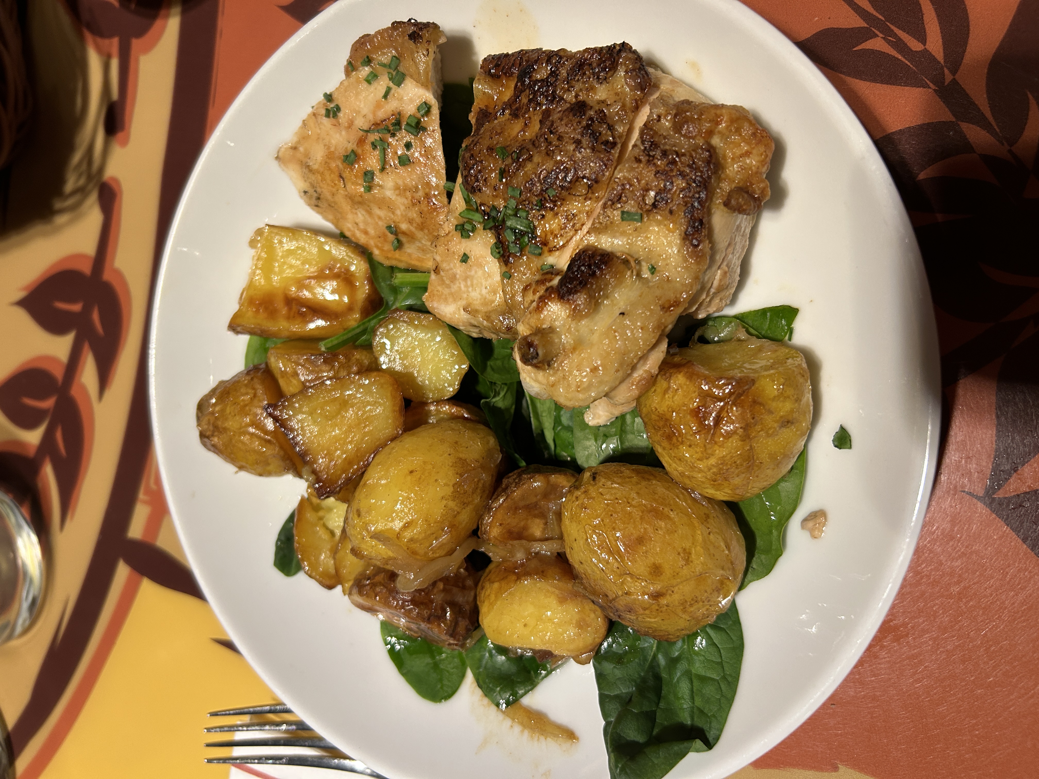 chicken dinner on a plate with potatoes and veg