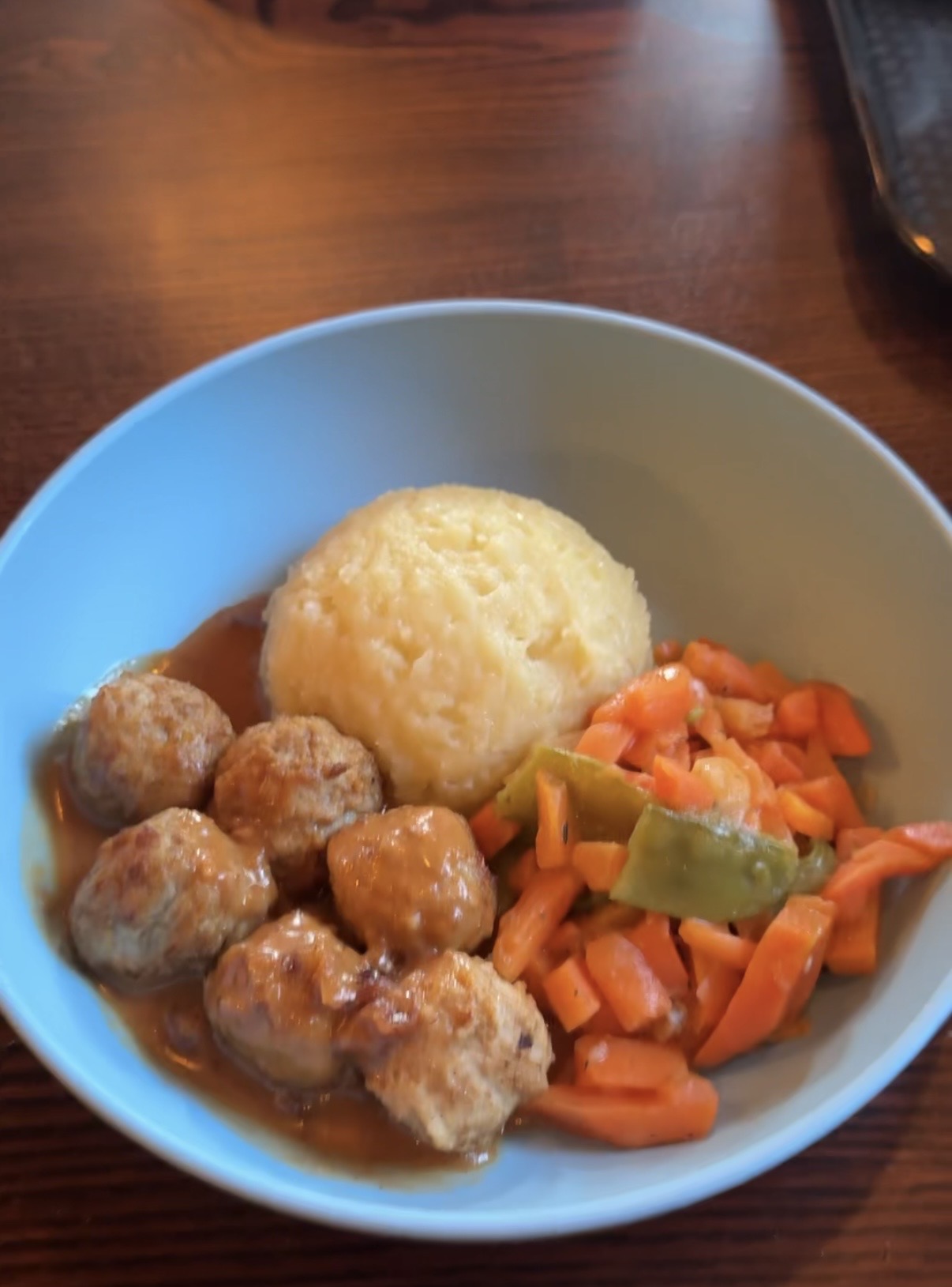 A bowl of turkey meatballs, mashed potato and vegetables