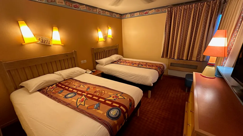 Image shows a brightly lit room with two double beds