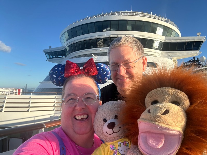 picture shows a man and women with a teddy and monkey puppet on a cruise ship